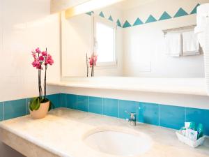 a bathroom with a sink and a vase with flowers at Apartment in Orosei near Marina di Orosei Beach in Orosei