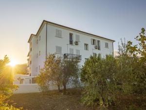 a white building with trees in front of it at Apartment in Orosei near Marina di Orosei Beach in Orosei