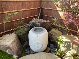 eine große Steinvase in einem Garten mit Felsen in der Unterkunft Kinnotake Saryo in Hakone + 53 Fotos