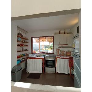 a kitchen with white cabinets and a stove top oven at Villa Lunahuana in Lunahuaná +13 photos