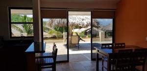 a dining room with a table and chairs and sliding glass doors at Punta cerritos in Mazatlán