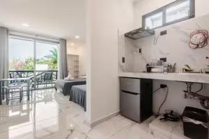 una cucina bianca con lavandino e una camera da letto di Alce33 a Cancún