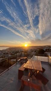 a picnic table on a balcony with a sunset at CasaValparaluz in Valparaíso