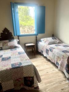 a bedroom with two beds and a window at Casa Donna Flor 2 Quartos Completa Centrinho com Garagem Coberta in Catas Altas