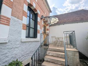 un escalier menant à un bâtiment avec une table et des chaises dans l'établissement Charme rural et détente près des châteaux de la Loire - FR-1-591-738, à Chabris