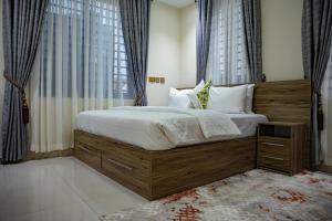 a bedroom with a large bed with a wooden headboard at Parkview Air B&B in Accra +5 photos
