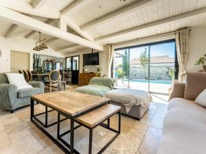 a living room with a couch and a table at Maison familiale avec piscine pour 9 personnes - FR-1-835-4 in Le Bois-Plage-en-Ré