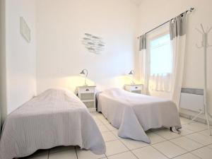 a white room with two beds and a window at Appartement avec terrasse au port d'Ars-en-Ré, Wi-Fi gratuit - FR-1-835-6 in Ars-en-Ré