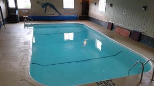 a large swimming pool in a gym with blue water at Clark's Beach Motel in Old Forge