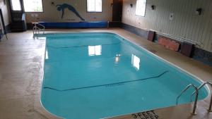 a large swimming pool in a gym with blue water at Clark's Beach Motel in Old Forge