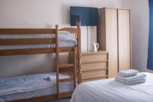 a bedroom with two bunk beds and a dresser at Wellesley Park Hotel in Great Yarmouth