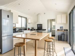 a kitchen with a large wooden table and stools at Maison spacieuse pour 8 pers. proche de la plage - FR-1-835-23 in Sainte-Marie-de-Ré +22 photos