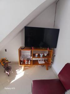a living room with a flat screen tv on a table at aconchego pe na areia in Ilhéus