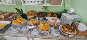 a table filled with various pastries and pies at Pousada Canto da Ilha in Ilha Comprida