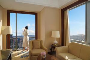 a woman looking out the window of a hotel room at Shangri-La Suzhou in Suzhou