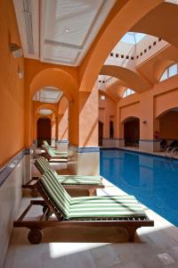 a pool with lounge chairs in a swimming pool at Diar Lemdina Hotel in Hammamet