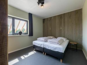 Un dormitorio con dos camas y una ventana. en Holiday Home in Vrouwenpolder near Beach, en Vrouwenpolder