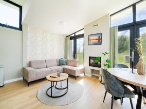 Oud-AdeにあるHoliday Home in Oud Ade near Kaag Lakesのソファとテーブルのあるリビングルーム