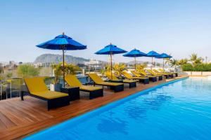a row of yellow chairs and umbrellas next to a swimming pool at Days Inn by Wyndham Patong Beach in Patong Beach