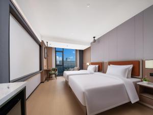 Llit o llits en una habitació de 义乌君忆云澜国际酒店 Yiwu Junyi Yunlan International Hotel