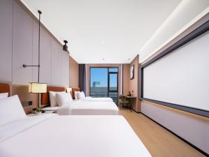 Llit o llits en una habitació de 义乌君忆云澜国际酒店 Yiwu Junyi Yunlan International Hotel