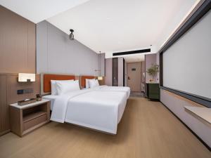 Llit o llits en una habitació de 义乌君忆云澜国际酒店 Yiwu Junyi Yunlan International Hotel