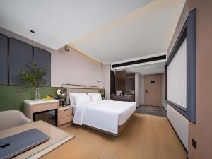 Llit o llits en una habitació de 义乌君忆云澜国际酒店 Yiwu Junyi Yunlan International Hotel
