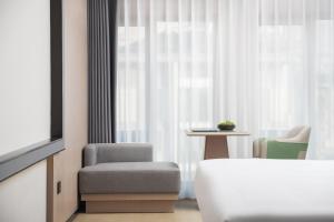 Llit o llits en una habitació de 义乌君忆云澜国际酒店 Yiwu Junyi Yunlan International Hotel