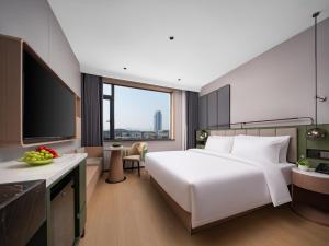 Llit o llits en una habitació de 义乌君忆云澜国际酒店 Yiwu Junyi Yunlan International Hotel