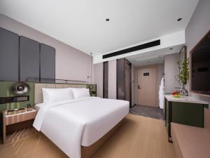 Llit o llits en una habitació de 义乌君忆云澜国际酒店 Yiwu Junyi Yunlan International Hotel