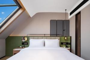 Llit o llits en una habitació de 义乌君忆云澜国际酒店 Yiwu Junyi Yunlan International Hotel