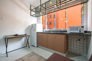 a kitchen with a refrigerator and a microwave at Apartamentos inCircle in Sao Paulo +22 photos