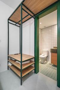 a bathroom with a toilet and a green pivot door at Apartamentos inCircle in Sao Paulo