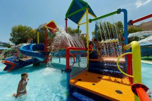 a boy playing on a water slide at a water park at Diar Lemdina Hotel in Hammamet