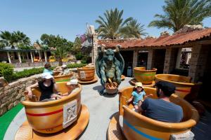 a group of people riding on a roller coaster at a theme park at Diar Lemdina Hotel in Hammamet