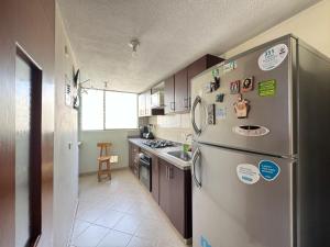 a kitchen with a stainless steel refrigerator and a sink at Cantabria in Manizales