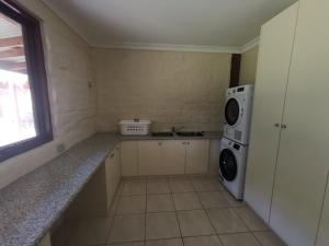 a kitchen with a washing machine and a microwave at Moon light Retreat in Whittlesea