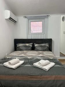 Un dormitorio con una cama con dos toallas encima. en Stan Na Dan Ninić, en Loznica