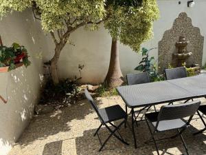 a table and chairs in a courtyard with trees at Casa Fibonacci en Oaxaca in Oaxaca City