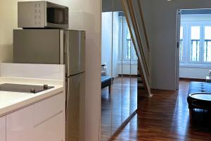 a kitchen with a refrigerator and a living room at Heritage Collection on Boon Tat in Singapore