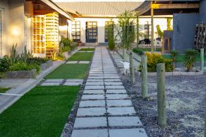 a garden with a stone path in front of a house at Kanana Villas - Maun Luxury One Bedroom Apartment in Maun