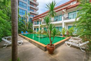 a swimming pool in front of a building at C199 Condo 1BR Walk to Lake, Beach, Bars & Market in Rawai Beach