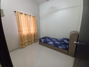 a small room with a bed and a curtain at Homestay DC 1 - wifi, netflix in Shah Alam