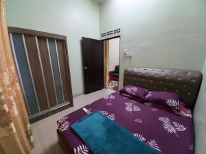 a bedroom with a bed with purple sheets at Homestay DC 1 - wifi, netflix in Shah Alam