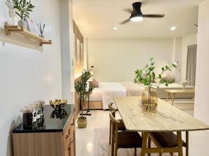 a living room with a bed and a table in a room at Studio Botanica I 2 mins to SRT in Bangkok