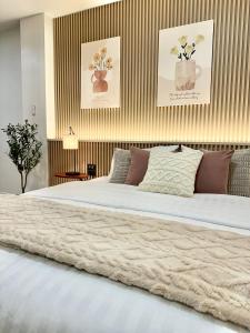 a bedroom with a large white bed with flowers on the wall at Studio Botanica I 2 mins to SRT in Bangkok