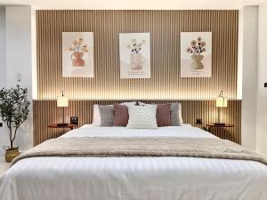 a bedroom with a large bed with flowers in vases at Studio Botanica I 2 mins to SRT in Bangkok