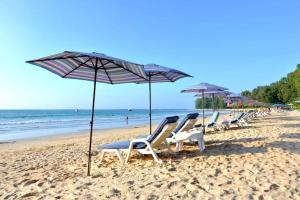 a row of lounge chairs and umbrellas on a beach at B9 Ватсап669З5В2I976 in Nai Yang Beach