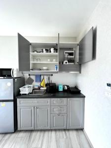 eine Küche mit grauen Schränken und einem Kühlschrank in der Unterkunft B9 Ватсап669З5В2I976 in Nai Yang Beach