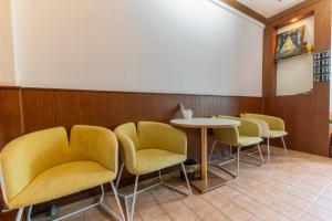 une salle d'attente avec des chaises jaunes et une table dans l'établissement Calmly Stay Ratchada, à Bangkok